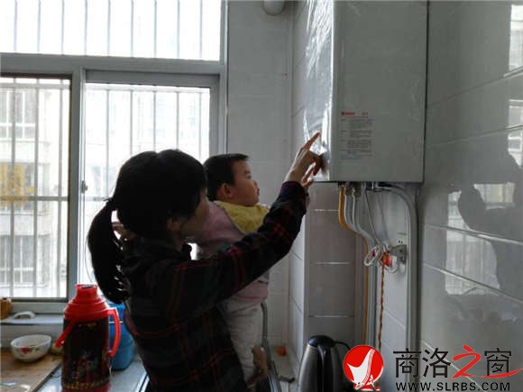 家住市區(qū)香菊小區(qū)的李女士正在操作自家剛剛安裝的燃?xì)獗趻鞝t，提升室內(nèi)的溫度。