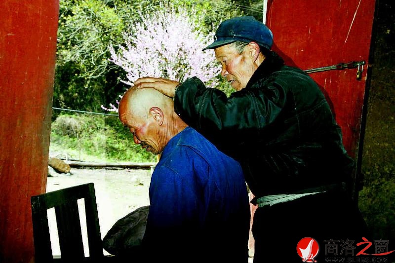 74歲的鄧自強(qiáng)在屋門口給71歲的弟弟鄧自貴剃頭。