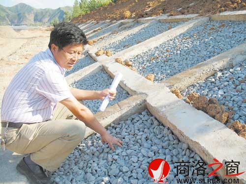 丹江治理工程建設(shè)管理處副處長李浩存在尚未完工的生態(tài)河堤旁為記者講解生態(tài)河堤原理。