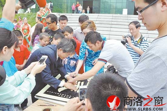 王鋒在牛背梁景區(qū)用麥稈現(xiàn)場(chǎng)作畫(huà)引起游客的濃厚興趣