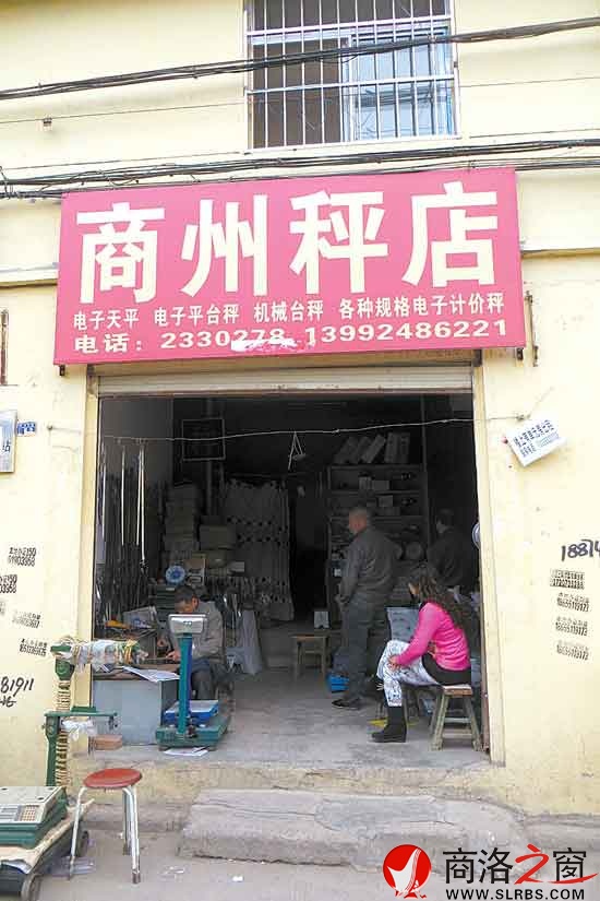 李寶曹專心致志地量秤桿的刻度