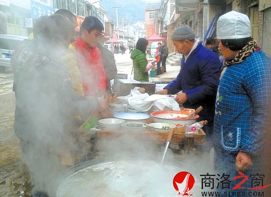 在熱氣騰騰的鍋邊，買羊肉套的食客排起了隊(duì)。